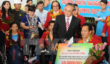 Đại diện các đơn vị, doanh nghiệp trao phần thưởng cho vận động viên Lê Văn Công-HCV Paralympic Rio 2016 và phá kỷ lục thế giới môn cử tạ. Ảnh: An Hiếu/TTXVN