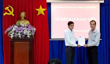 Đồng chí Nguyễn Thanh Hiền, Bí thư chi bộ, Phó Trưởng Ban Tuyên giáo Tỉnh ủy trao quyết định kết nạp đảng viên (ảnh mang tính minh họa). Ảnh: Tấn Quân 