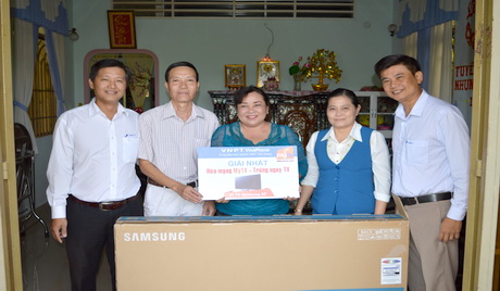 Ông Trịnh Quốc Khánh, Phó Giám đốc Trung tâm Kinh doanh VNPT - Tiền Giang  trao giải Nhất cho khách hàng Phạm Thị Nhẫn, ấp Bình Long, xã Song Bình (Chợ Gạo).