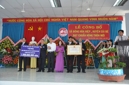 Ông Võ Văn Bình, Phó Bí thư Tỉnh ủy và ông Nguyễn Văn Nhã, Trưởng ban Tổ chức Tỉnh ủy trao Bằng Công nhận và Công trình phúc lợi trị giá 1 tỷ đồng cho xã nông thôn mới Kim Sơn.