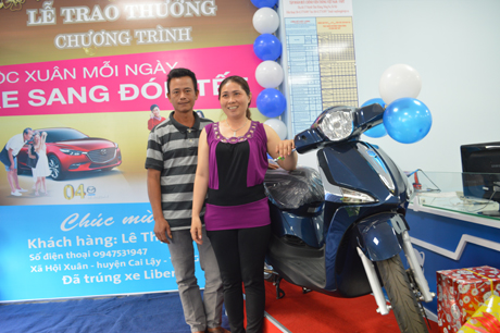 Vợ chồng chịThiêm bên chiếc xe mới đầu năm.