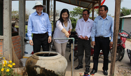 Đại diện nhà tài trợ mở van nước tại nhà người dân.
