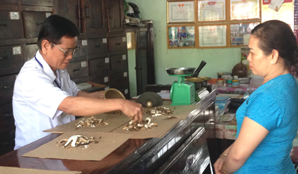 Lương y Trần Bửu Lộc bốc thuốc cho bệnh nhân.