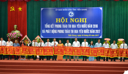 Đại diện lãnh đạo UBND phường 1, TX. Gò Công  (nữ mặc áo dài thứ 9 từ phải qua) nhận Cờ thi đua xuất sắc của UBND tỉnh tại Hội nghị Tổng kết phong trào  thi đua yêu nước năm 2016.