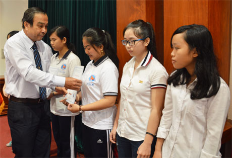 Ông Nguyễn Hữu Đức, nguyên Tổng Biên tập Báo Ấp Bắc trao học bổng cho học sinh các hoàn khó khăn.