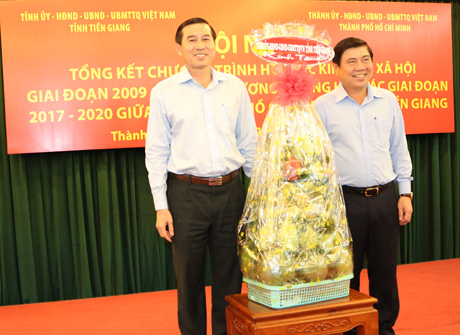 Ông Võ Văn Bình, Phó Bí thư Tỉnh ủy Tiền Giang và ông Tất Thành Cang, Phó Bí thư Thường trực Thành ủy TP. Hồ Chí Minh trao quà lưu niệm giữa hai địa phương.