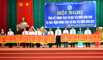 Đại diện lãnh đạo Quỹ TDND Tân Mỹ Chánh (bìa trái) nhận Cờ thi đua xuất sắc của UBND tỉnh năm 2016.