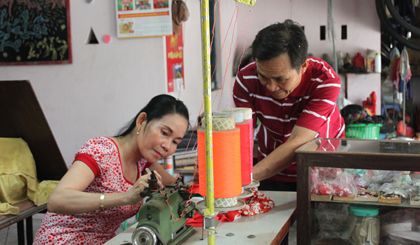 Anh Minh giúp vợ chỉnh lại bàn máy may.