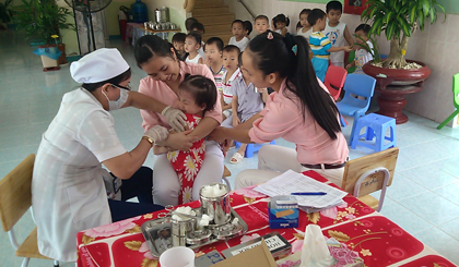 Cán bộ y tế tiêm vắc-xin phòng bệnh sởi - rubella cho trẻ.
