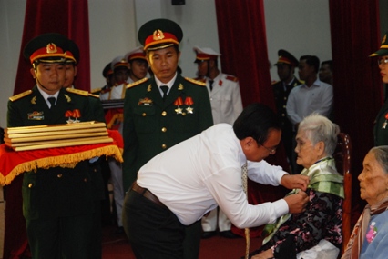Phó Bí thư Tỉnh ủy Võ Văn Bình trân trọng cài huy hiệu Bà Mẹ Việt Nam anh hùng lên ngực áo Bà Mẹ vừa được Chủ tịch Nước phong tặng danh hiệu cao quý