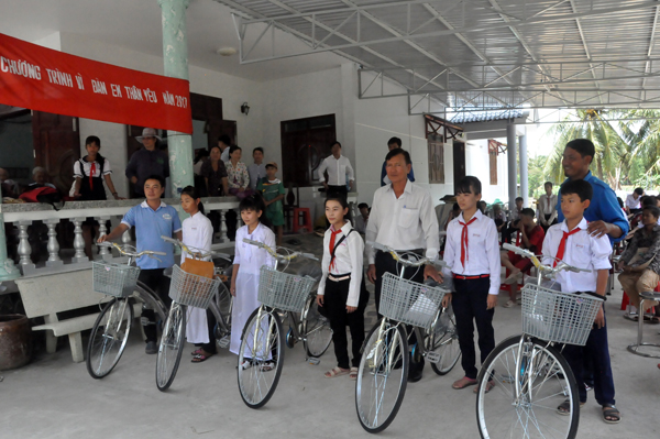Đại diện Hội Khuyến học huyện Chợ Gạo 5trao xe đạp cho các em học sinh.