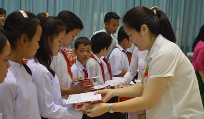 Bà Phó Tổng giám đốc công ty TNHH Dụ Đức Việt Nam trao học bổng cho các em có hoàn cảnh khó khăn.