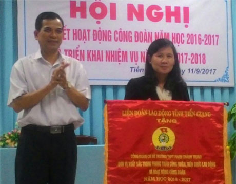 Ông Trương Văn Hiền, Chủ tịch LĐLĐ tỉnh Tiền Giang trao Cờ thi đua xuất sắc của LĐLĐ tỉnh cho CĐCS trường THPT Phạm Thành Trung.