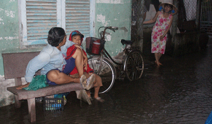 Nước ngập làm cho việc đi lại, sinh hoạt của người dân gặp nhiều khó khăn.