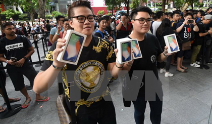Khách hàng đầu tiên mua điện thoại iPhone X của Apple tại Singapore ngày 3/11. (Nguồn: AFP/TTXVN)