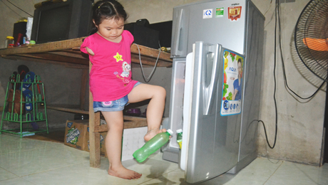 Bé tự mở tủ lạnh lấy nước uống mà không cần ai hỗ trợ.