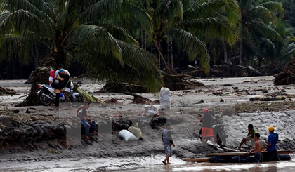 Người dân di chuyển bằng bè để qua sông sau bão Tembin tại tỉnh Lanao del Norte, Philippines ngày 23/12. (Nguồn: THX/TTXVN)
