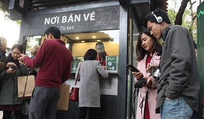 Khách du lịch trong nước và quốc tế hào hứng với hệ thống biển chỉ dẫn mới, thuyết minh tự động tại Văn Miếu - Quốc Tử Giám. Ảnh: Báo ANTĐ