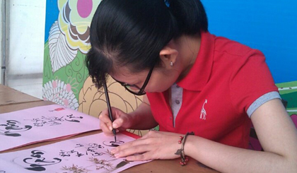Nghệ nhân vẽ chữ thư pháp trên lụa.