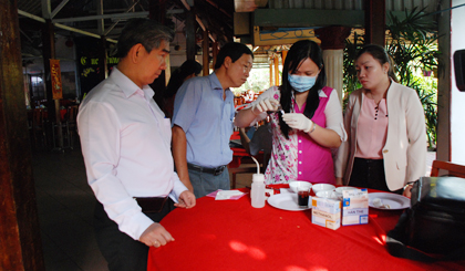 Tiến hành test nhanh methanol trong rượu bán tại một cơ sở kinh doanh ăn uống.