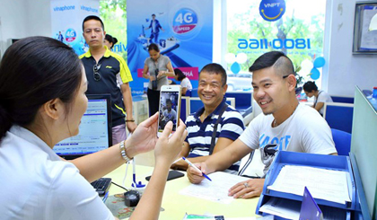 Nhân viên chụp ảnh chân dung khách hàng đến đăng ký thuê bao trả trước mới tại Trung tâm kinh doanh VNPT Vinaphone Hà Nội. (Ảnh: Minh Quyết/TTXVN)