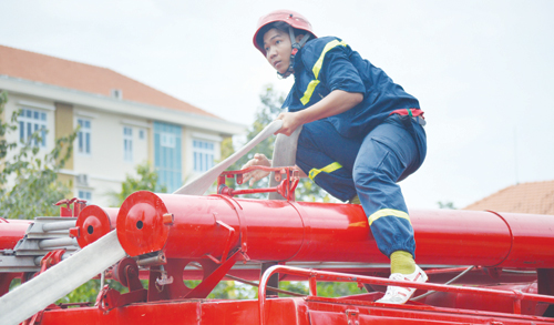 Khẩn trương lấy nước chữa cháy từ xe chuyên dụng.                                                       	                                                                                 Ảnh: TUẤN LÂM