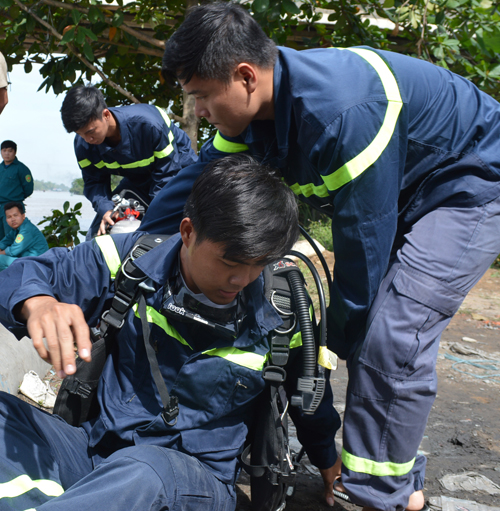 Bị kiệt sức do liên tục nhiều giờ trầm mình dưới sông  cứu vợ chồng trẻ bị cuốn vào buồng máy khi sà lan chìm. Ảnh: TUẤN LÂM