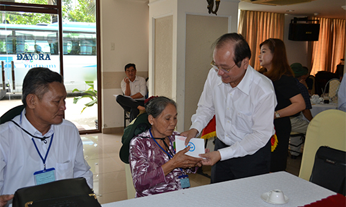 Phó Chủ tịch UBND tỉnh Trần Thanh Đức cài hoa và trao quà cho người có công trước chuyến tham quan.
