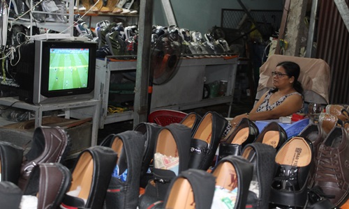 Chị Hạnh bán giày ở TP. Mỹ Tho mở cửa hàng đến tận 23h để vừa xem World Cup vưa bán hàng