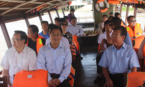 Đoàn công tác đi thuyền đi trên sông Tiền.