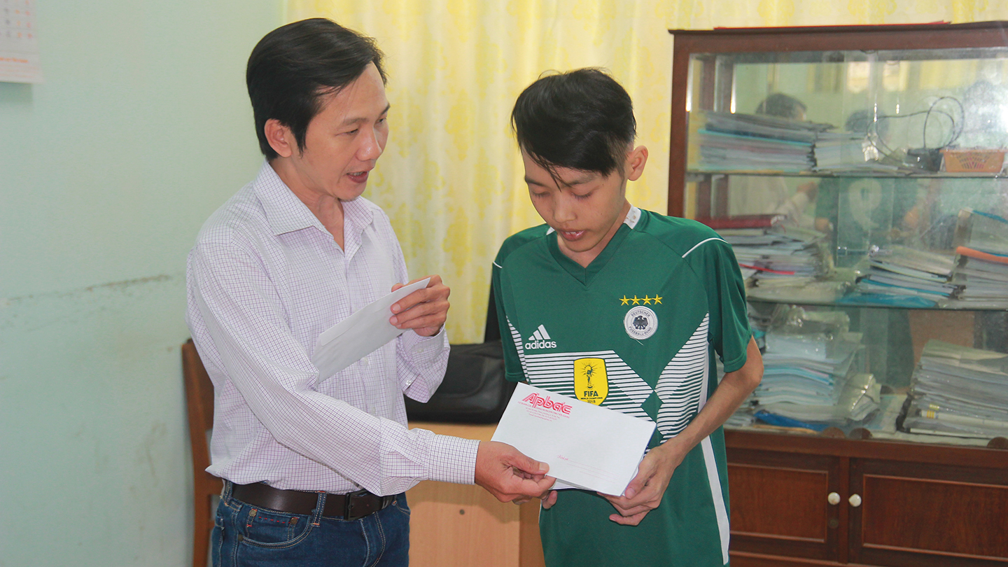 Phó Tổng Biên tập Báo Ấp Bắc Nguyễn Trọng Tấn trao tiền của bạn đọc giúp đỡ em Nguyễn Phan Quí.
