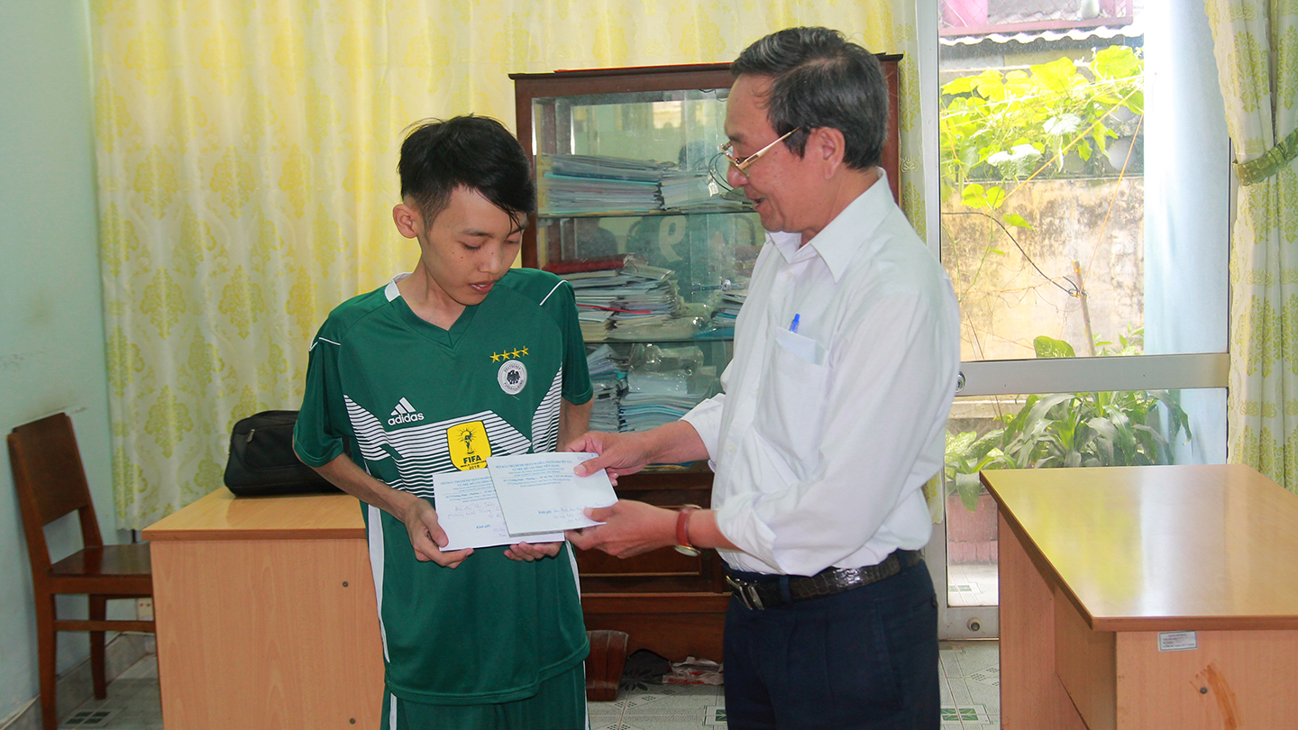 Chỉ tịch Hội BTBNN, NKT&TMC tỉnh Tiền Giang Phan Văn Hà trao tiền của bạn đọc giúp đỡ em Nguyễn Phan Quí.