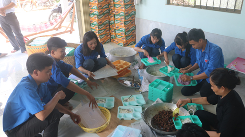 Đoàn viên huyện Tân Phú Đông tình nguyện chuẩn bị các phần cơm trưa cho các thí sinh tham gia Kỳ thi THPT Quốc gia năm 2018 vừa qua.