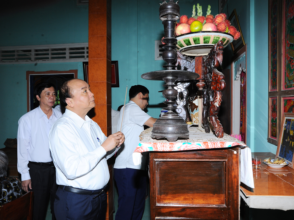 Thủ tướng Chính phủ Nguyễn Xuân Phúc thắp nhang tại nhà mẹ Đặng Thị Bảy.