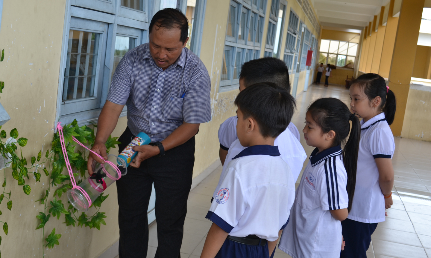 Thầy Lê Ngọc Thanh hướng dẫn học sinh sử dụng sách tại mô hình  “Khu vườn tri thức xanh”.