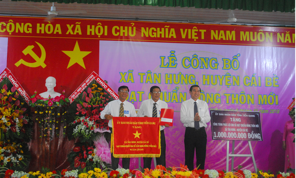Đồng chí Lê Văn Hưởng đại diện UBND tỉnh tặng cờ cho xã Tân Hưng.