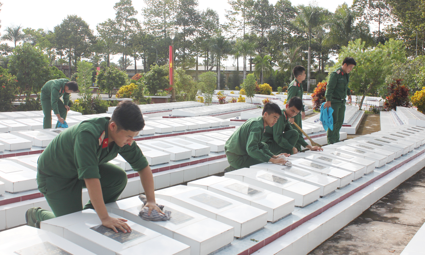 Cán bộ, chiến sĩ Lực lượng vũ trang lau chùi mộ liệt sĩ tại Nghĩa trang Liệt sĩ tỉnh.            Ảnh: PHƯƠNG MAI