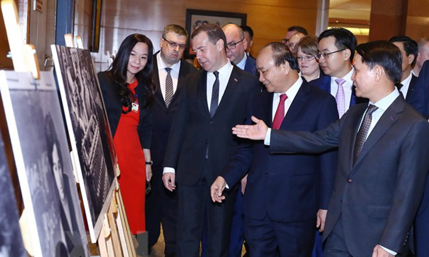 Thủ tướng Liên bang Nga Dmitry Medvedev và Thủ tướng Nguyễn Xuân Phúc tham quan Trưng bày ảnh Việt-Nga: Quan hệ hữu nghị truyền thống và hợp tác toàn diện. (Ảnh: Thống Nhất/TTXVN)