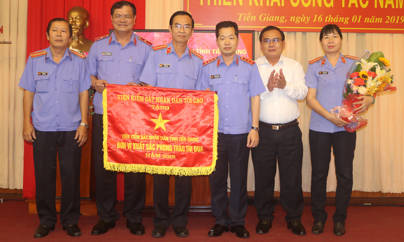 Đồng chí Võ Văn Bình, Phó Bí thư Thường trực Tỉnh ủy, Trưởng Đoàn Đại biểu Quốc hội đơn vị tỉnh Tiền Giang (thứ hai từ phải sang) tặng hoa chúc mừng VKSND tỉnh nhận cờ thi đua của VKSND tối cao.