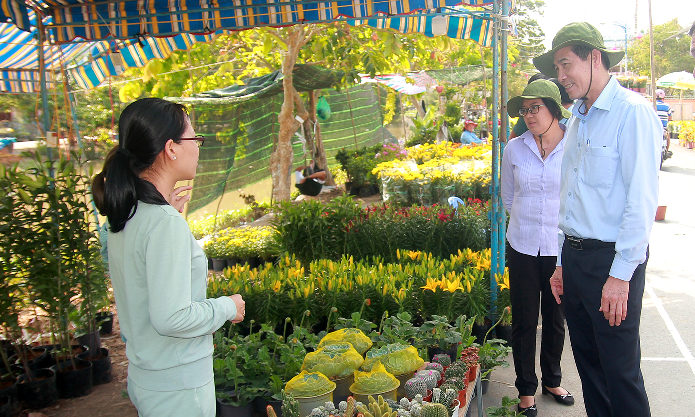 Đồng chí Lê Văn Hưởng trao đổi với các hộ kinh doanh tại chợ hoa xuân huyện Gò Công Tây.