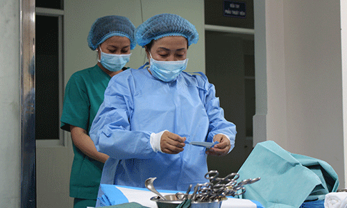 Bác sĩ thay đồ bảo hộ trước khi lên ca mổ. 