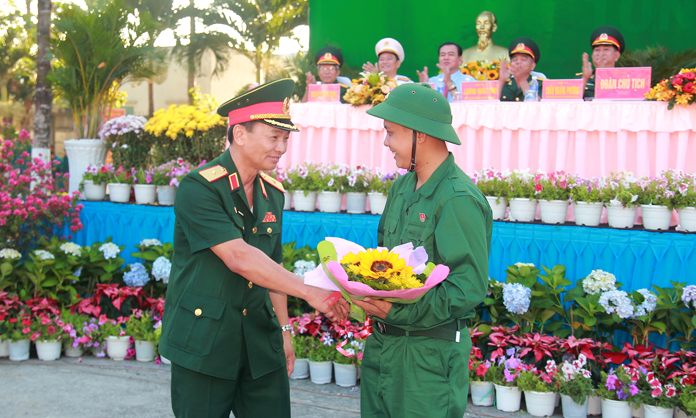 Thiếu tướng Đoàn Thanh Xuân tặng hoa cho thanh niên Nguyễn Hoài Phước.
