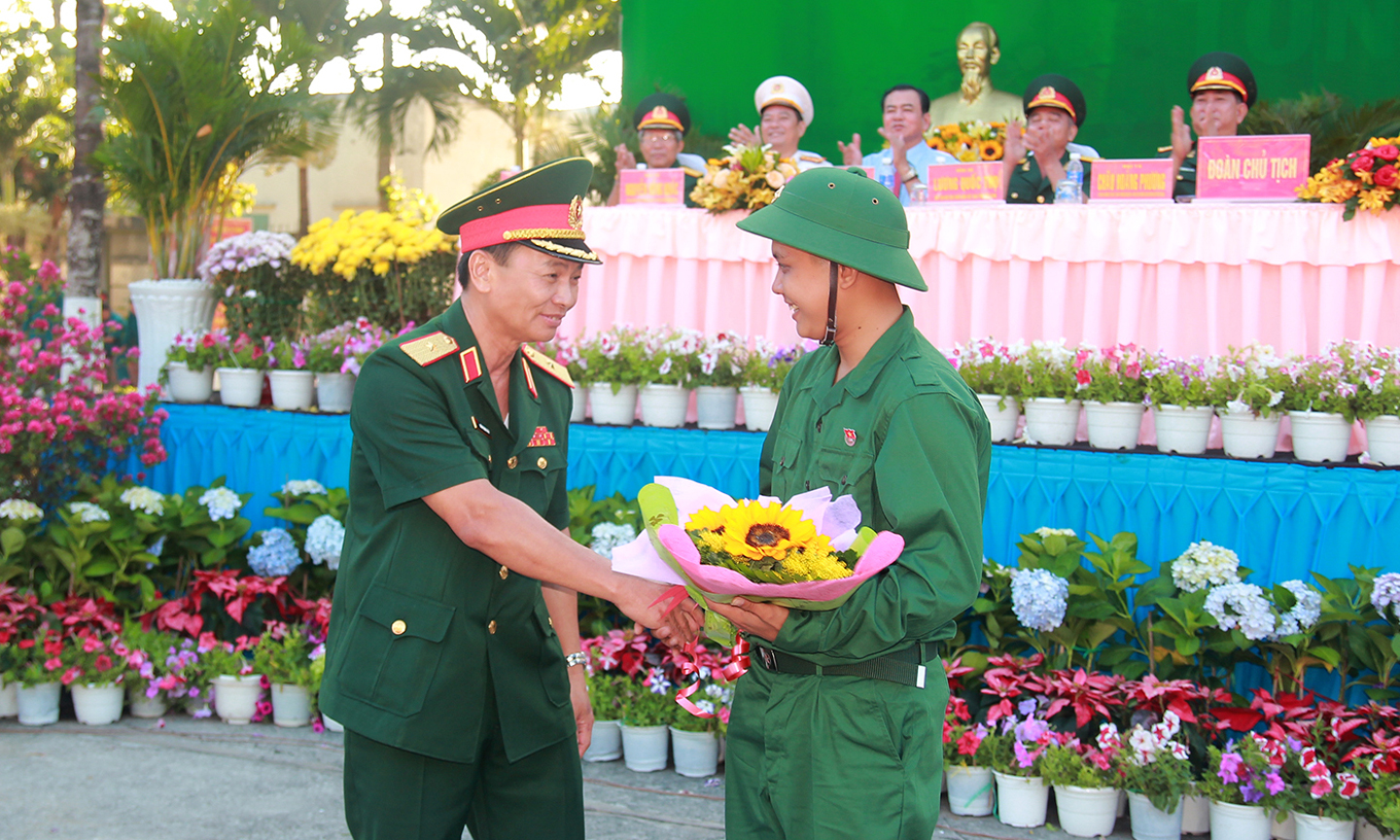 Thiếu tướng Đoàn Thanh Xuân, Ủy viên Ban Thường vụ Đảng ủy, Phó Chính ủy Quân khu 9 tặng hoa cho đại diện thanh niên TP. Mỹ Tho lên đường nhập ngũ.  Ảnh: VĂN THẢO