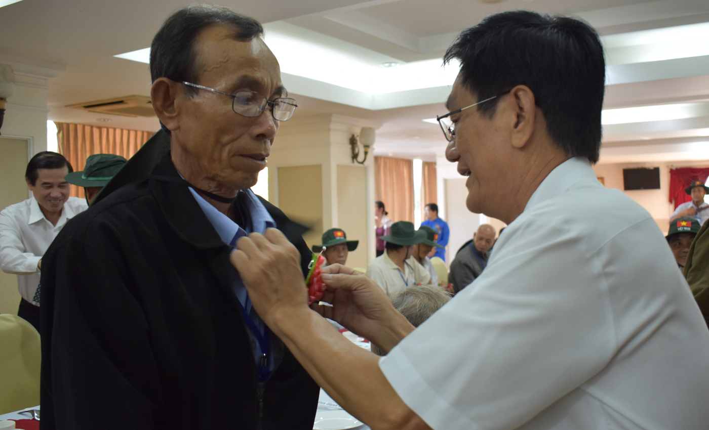Đồng chí Phạm Minh Trí, Giam đốc sở Lao động, thương binh và xã hội tặng cài hoa cho người có công