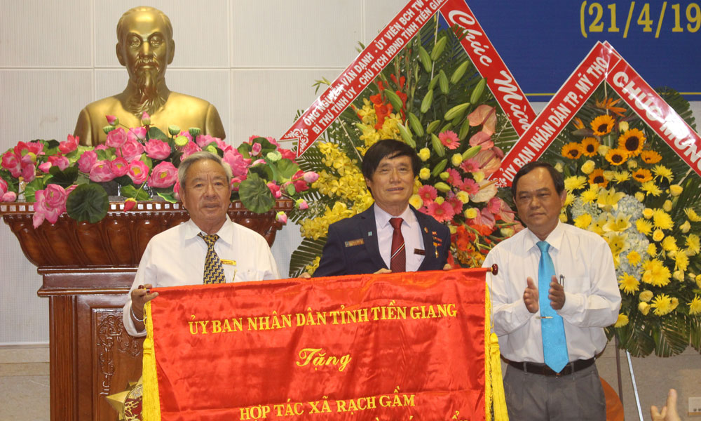 Lãnh đạo HTX Rạch Gầm nhận bức Trướng của UBND tỉnh.