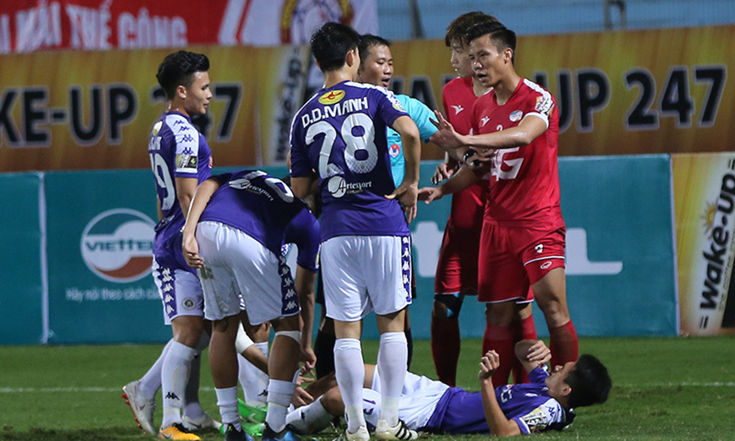 Văn Kiên (Câu lạc bộ Hà Nội) nằm sân sau tình huống vào bóng thô bạo của Quế Ngọc Hải (Viettel). 		                                                                                                                                                                                         Ảnh: Vietnamnet.vn