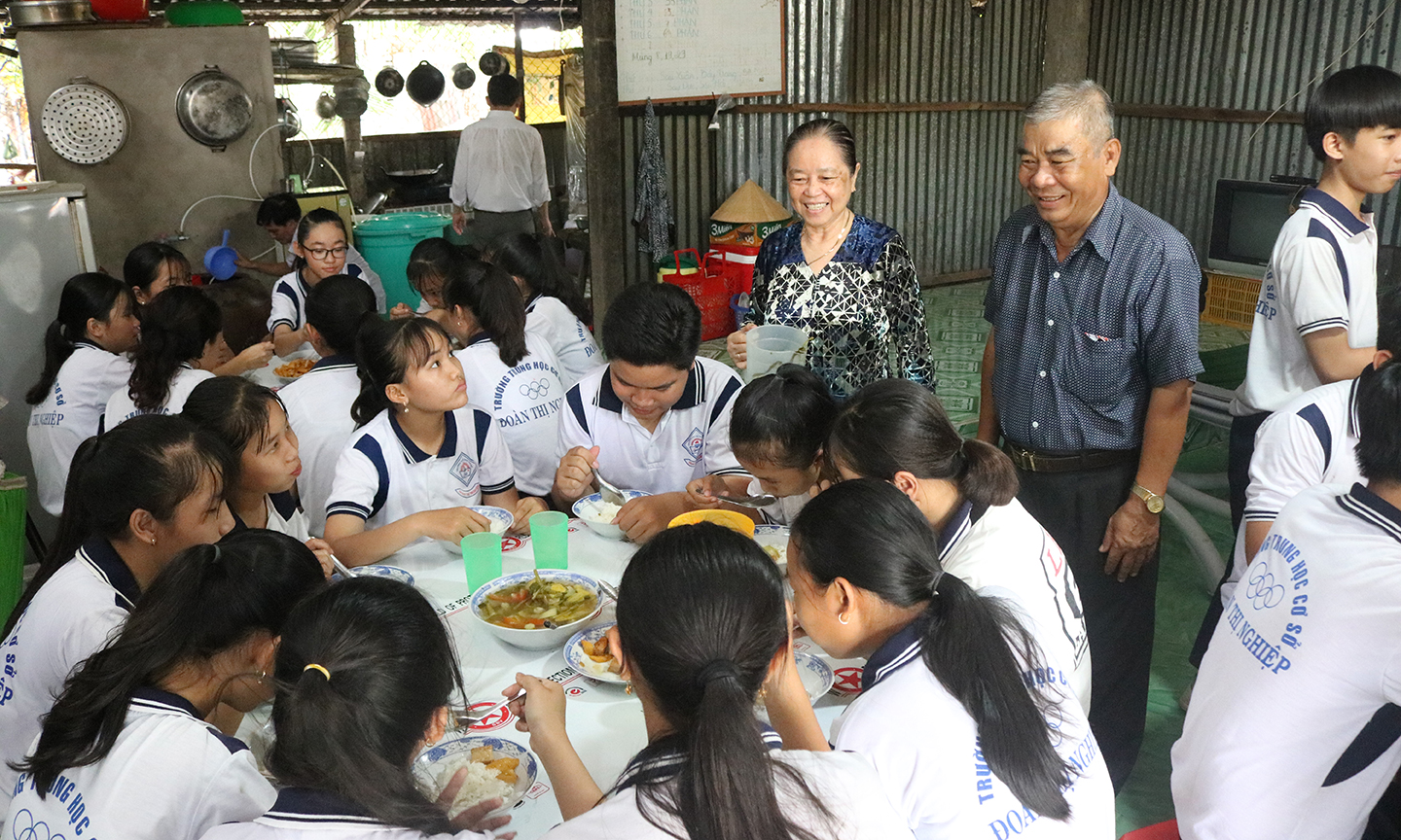 Ông Nghĩa thăm hỏi học sinh dùng cơm miễn phí tại “Bếp ăn tình thương”.