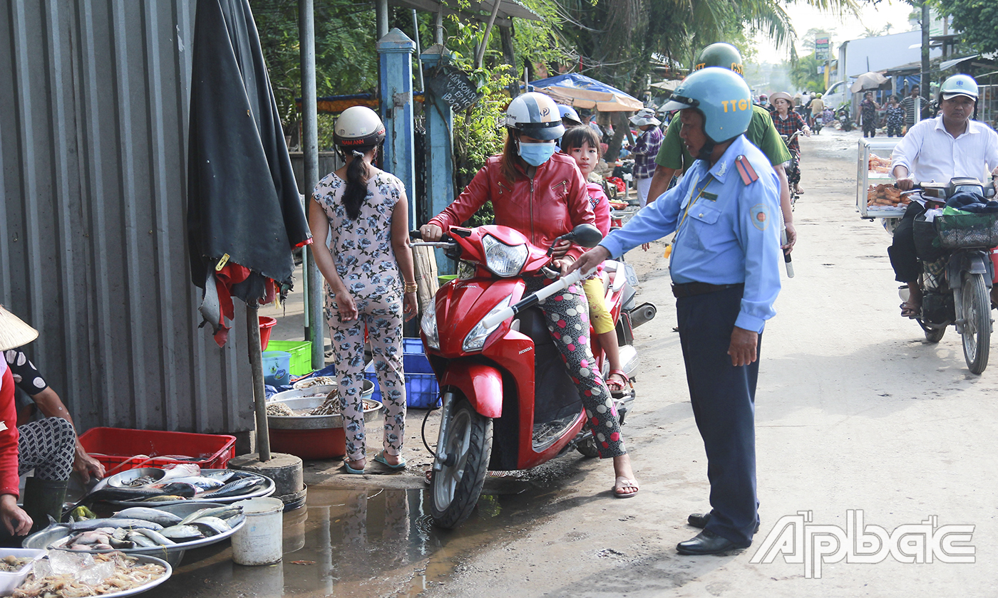 Lực lượng chức năng tuyên truyền, nhắc nhở các hộ kinh doanh không vi phạm hành lang an toàn giao thông. 