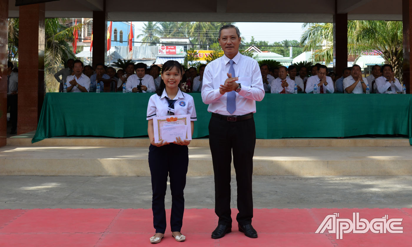 Bí thư Huyện Uỷ Chợ Gạo Ngô Hữu Thệ khen thưởng em Trần Thị Ngọc Trang, đạt giải ba môn Văn cấp quốc gia