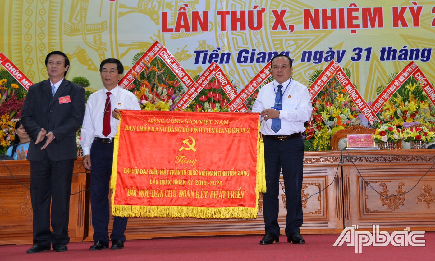 Đồng chí Nguyễn Văn Danh trao tặng Bức trướng với dòng chữ “Đổi mới - Dân chủ-Đoàn kết - Phát triển” của Tỉnh ủy cho Ủy ban MTTQ Việt Nam tỉnh Tiền Giang.